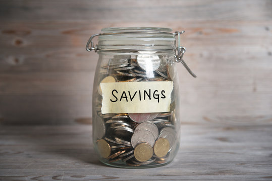Glass jar labeled "Savings" filled with coins, representing money growing tax-free in a TFSA